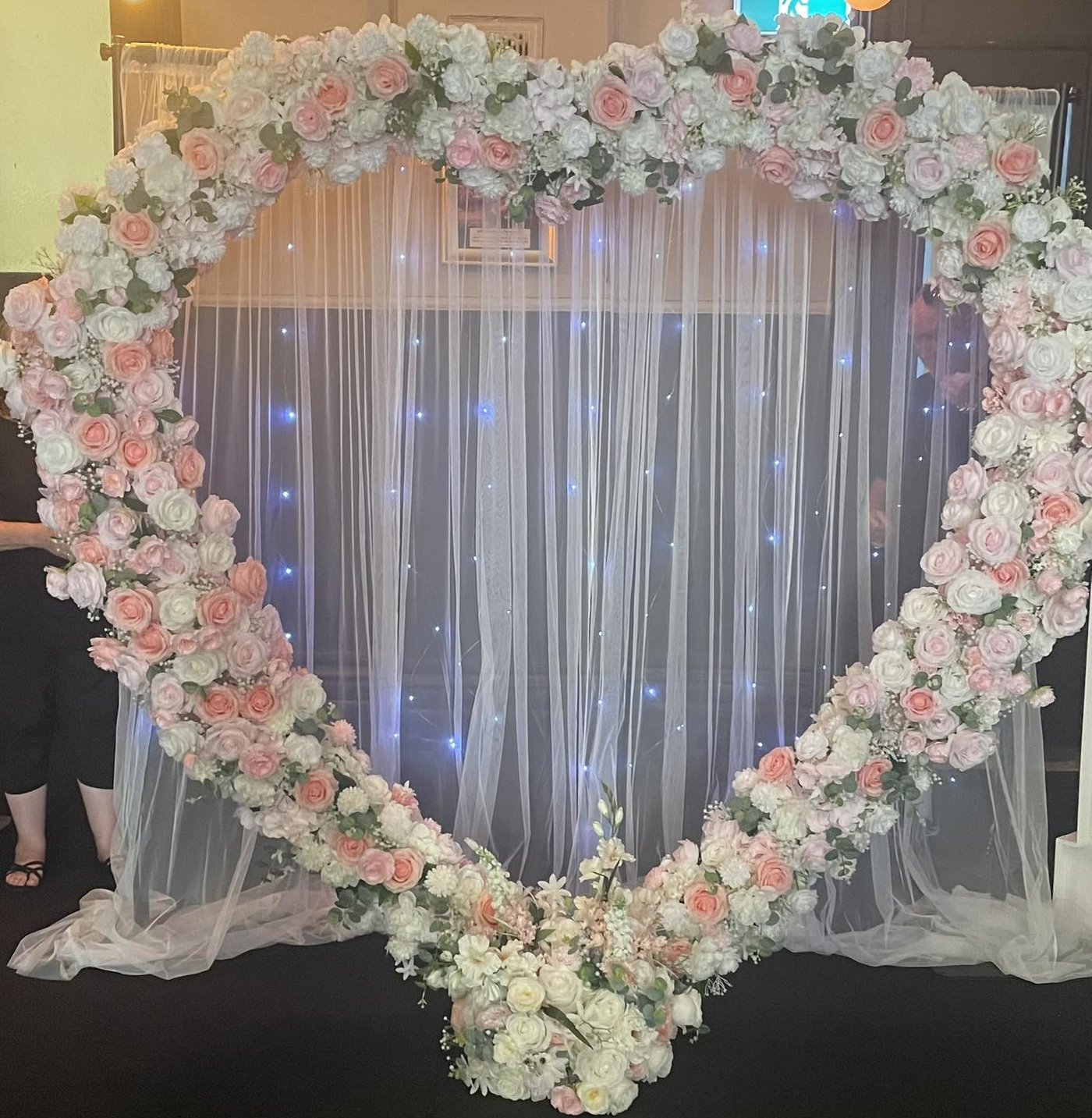 Pink and white floral heart arch with fairy lights
