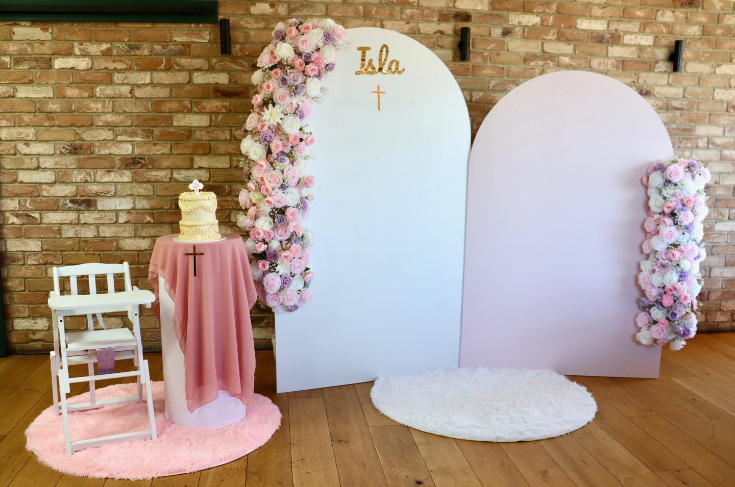 Christening backdrop with arches, florals and cake